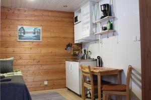 a small kitchen with a table and a refrigerator at Scandinavian Dream Cottages Vikajarvi- Rovaniemi in Vikajärvi