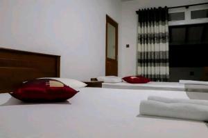 a bedroom with two beds with towels on the bed at Blue Moon Villa in Waskaduwa