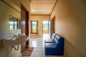 a bathroom with a sink and a blue chair at Griya Astoeti By ARBA in Kopo 2
