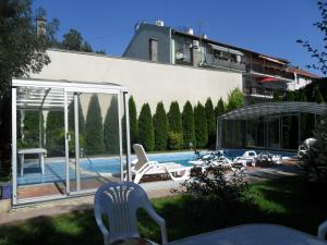 a swimming pool with chairs and a building at BL Luxus Apartman in Szeged