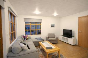 a living room with a couch and a tv at Malarhorn Accommodations in Drangsnes