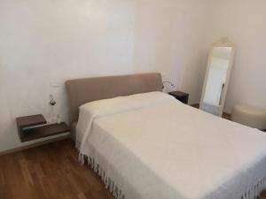 a bedroom with a white bed and a mirror at Flat26 in Castiglion Fiorentino
