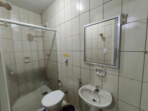 a bathroom with a sink and a toilet and a mirror at Hotel Mirian in Patos de Minas +55 photos