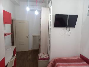 a small room with a bed and a tv on a wall at Flat26 in Castiglion Fiorentino +8 photos