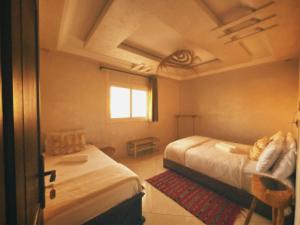 a bedroom with two beds and a window at hyle Surfhouse in Agadir