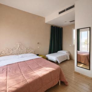 a hotel room with a bed and a mirror at Hotel Fiamma & SPA Cesenatico in Cesenatico