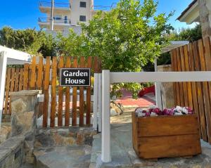 a garden house sign in front of a fence at Aggelou Apartments-10 mins from Athens airport in Spata +57 photos