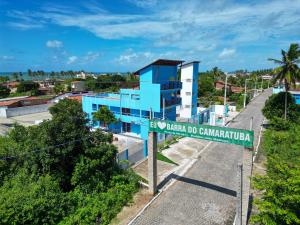 a street sign in front of a blue building at Pousada Encantos do Mar in Barra de Camaratuba