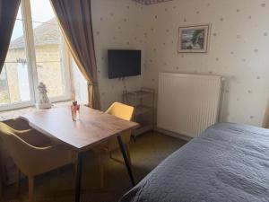 a bedroom with a table and a bed and a television at Bed & Breakfast Chateau Saintonge in Le Chevain