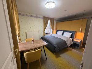 a bedroom with a bed and a wooden table at Bed & Breakfast Chateau Saintonge in Le Chevain