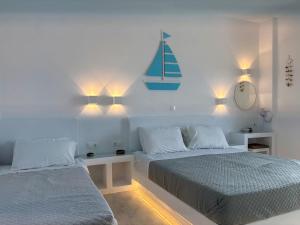 a bedroom with two beds and lights on the wall at Kleanthi Apartments in Drios +188 photos