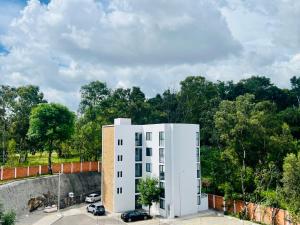a white building with cars parked in a parking lot at Full Kitchen, Great View, Historic Center, Quiet in Puebla