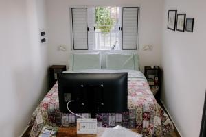 a bedroom with a bed with a tv on it at Joia do Pepira in Brotas