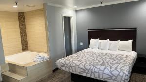 a hotel room with a bed and a bath tub at Laguna Inn and Suites in San Juan Capistrano