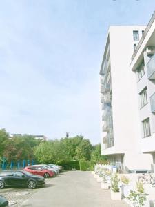 a parking lot with cars parked next to a building at The Solstice Studio Apartment in Cluj-Napoca