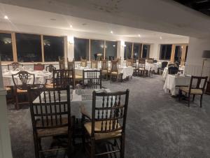 a dining room with white tables and chairs and tablesearcher at Loch's Heaven 67 in Kirkcowan