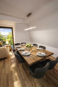 a dining room with a wooden table and chairs at Ferienwohnung Niki am Straussee Seeblick und Kamin für bis zu 12 Personen in Strausberg