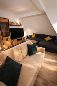 a living room with a couch and a flat screen tv at Ferienwohnung Niki am Straussee Seeblick und Kamin für bis zu 12 Personen in Strausberg
