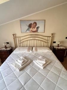 a bedroom with a white bed with two towels on it at La Fabiola in Langhirano