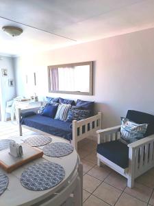 a living room with a couch and a table at Hartenbos - Bayview 230m from beach in Mossel Bay
