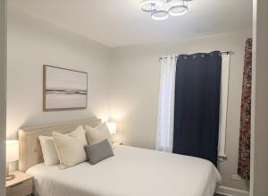 a bedroom with a white bed with a blue curtain at City Retreat in Chicago