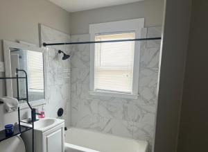 a bathroom with a tub and a sink and a window at City Retreat in Chicago