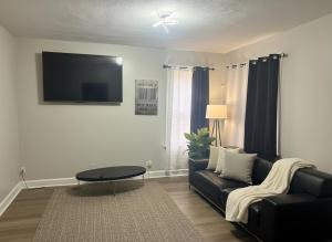 a living room with a couch and a tv on the wall at City Retreat in Chicago