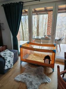 a crib in a living room with a rug at Vikendica Šššuma in Srbac