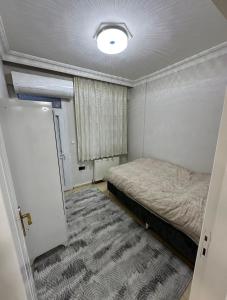 a small bedroom with a bed and a rug at Ozan Konukevi in Hatay