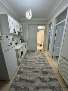 a kitchen with white appliances and a rug on the floor at Ozan Konukevi in Hatay