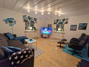 a living room with a couch and a tv at Guesthouse in Öjebyn