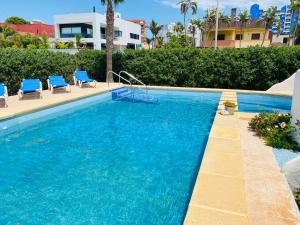 a swimming pool with two blue chairs and a pool at Luxuriöses Chalet mit privatem Pool in Roquetas de Mar