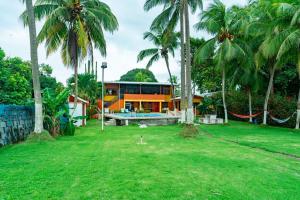 an orange house with palm trees in a yard at Casa Rector - Beach House Rental in El Roble