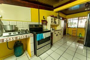 a kitchen with yellow walls and a stove top oven at Casa Rector - Beach House Rental in El Roble