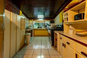 a large kitchen with yellow walls and white cabinets at Casa Rector - Beach House Rental in El Roble +18 photos