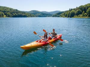 two people in a kayak on a lake at Muchatki domki z sauną in Zagórze +48 photos