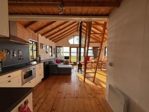 a kitchen and living room with wooden ceilings at Vakantiehuis - De Smidse in Haren