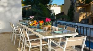 a white dining table and chairs on a balcony at Villa Playa del Sur A 250 metros de una magnifica playa Capacidad más de 16 AC 6 Suites Piscina XL in Torredembarra