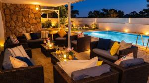 a patio with couches and a swimming pool at night at Villa Playa del Sur A 250 metros de una magnifica playa Capacidad más de 16 AC 6 Suites Piscina XL in Torredembarra