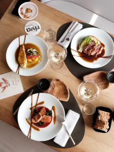 a wooden table with plates of food on it at Maison Bérard Hôtel - Restaurant - Spa in La Cadière-dʼAzur