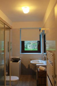 a bathroom with a sink and a toilet and a window at Villa Manuela-Lake View in Brenzone sul Garda +39 photos