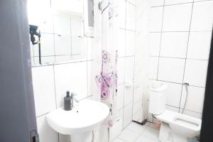 a white bathroom with a sink and a toilet at Complexe A8CLOS in Douala +63 photos