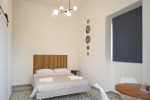a white bedroom with a bed and a table at Atmosfere 21 in Pagani