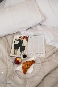 a book and a plate of food on a bed at Atmosfere 21 in Pagani