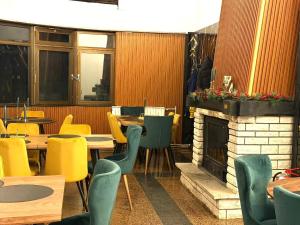 a restaurant with tables and chairs and a fireplace at Goldel Resort in Delčevo