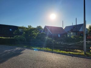 a house on a street with the sun in the sky at B&B Koe en Kussen in Bodegraven