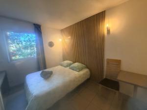 a small bedroom with a bed and a window at Le Clos d'Aix studio 102 in Aix-en-Provence