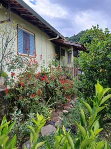 a house with red flowers in front of it at Casa Amarela in Bocaina de Minas