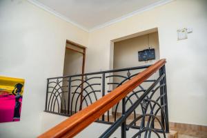 a staircase in a house with a television on the wall at Legacy by Fralec in Nyeri +11 photos
