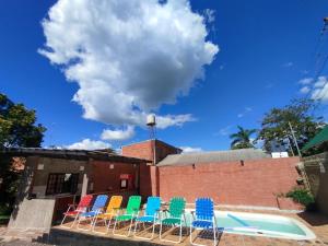 a group of chairs sitting next to a pool at Cápsula 127 in Puerto Iguazú
